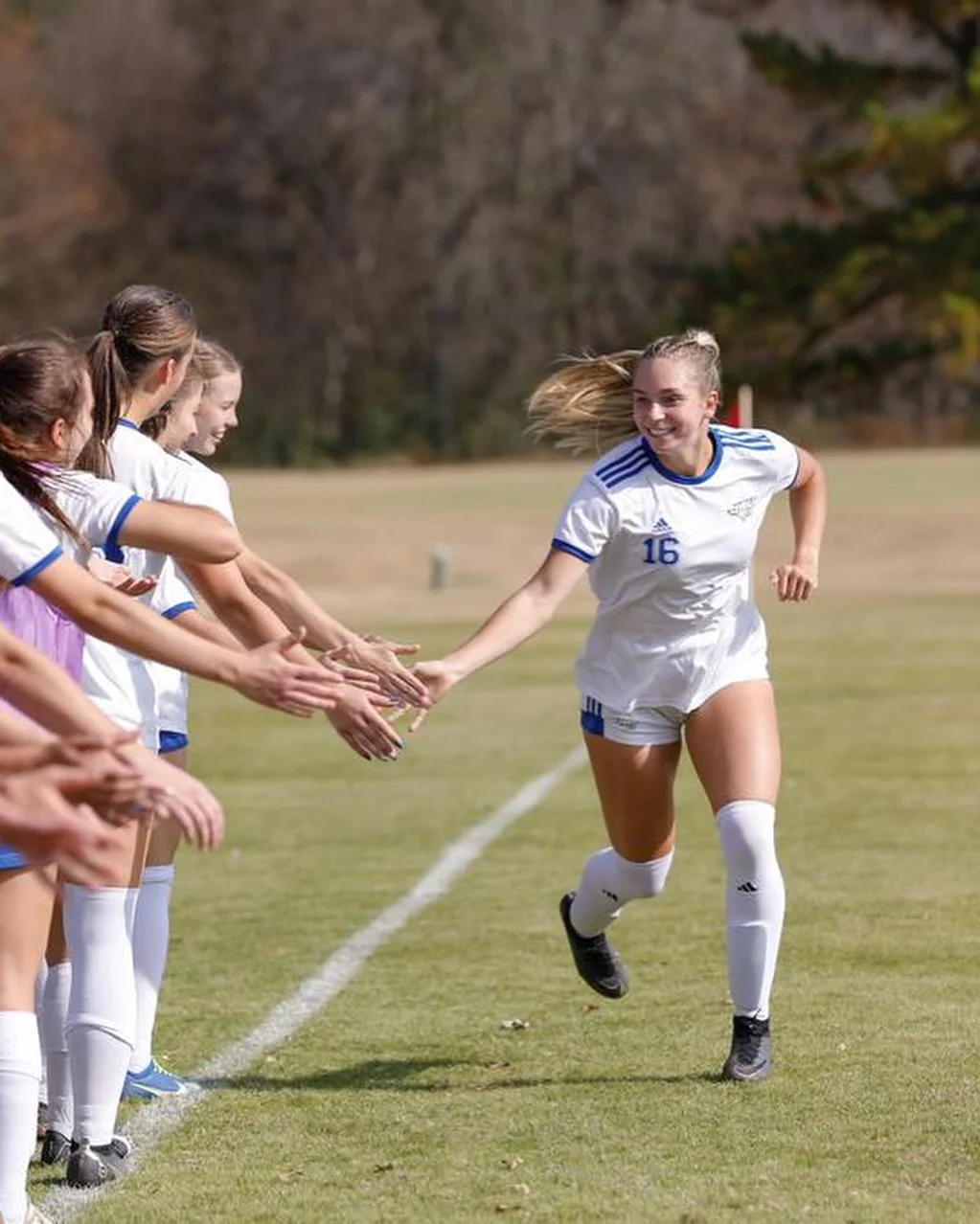 Lauren greeting her JBU teammates with high fives